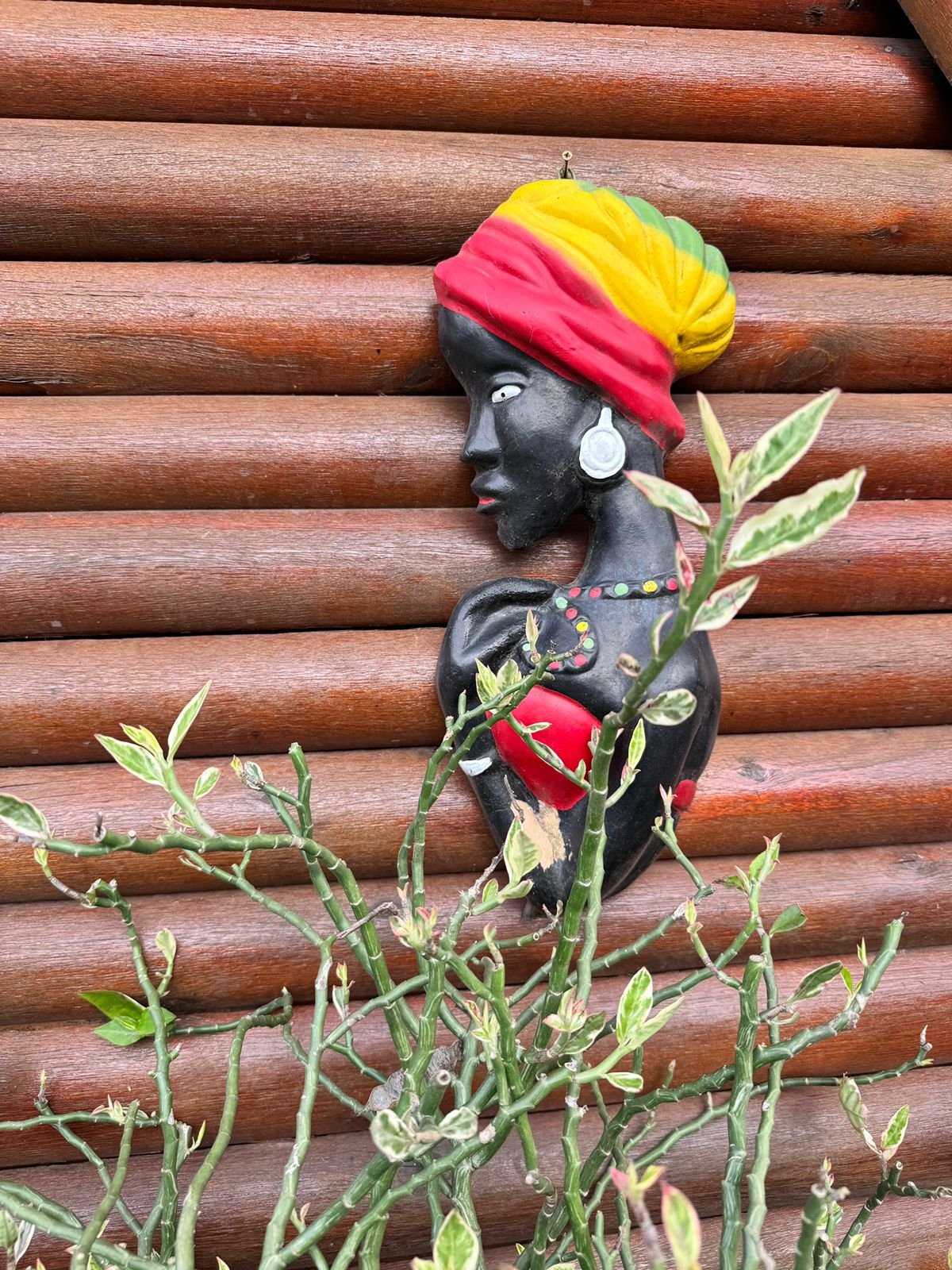 Figura de cerámica afroparaguaya entre las plantas