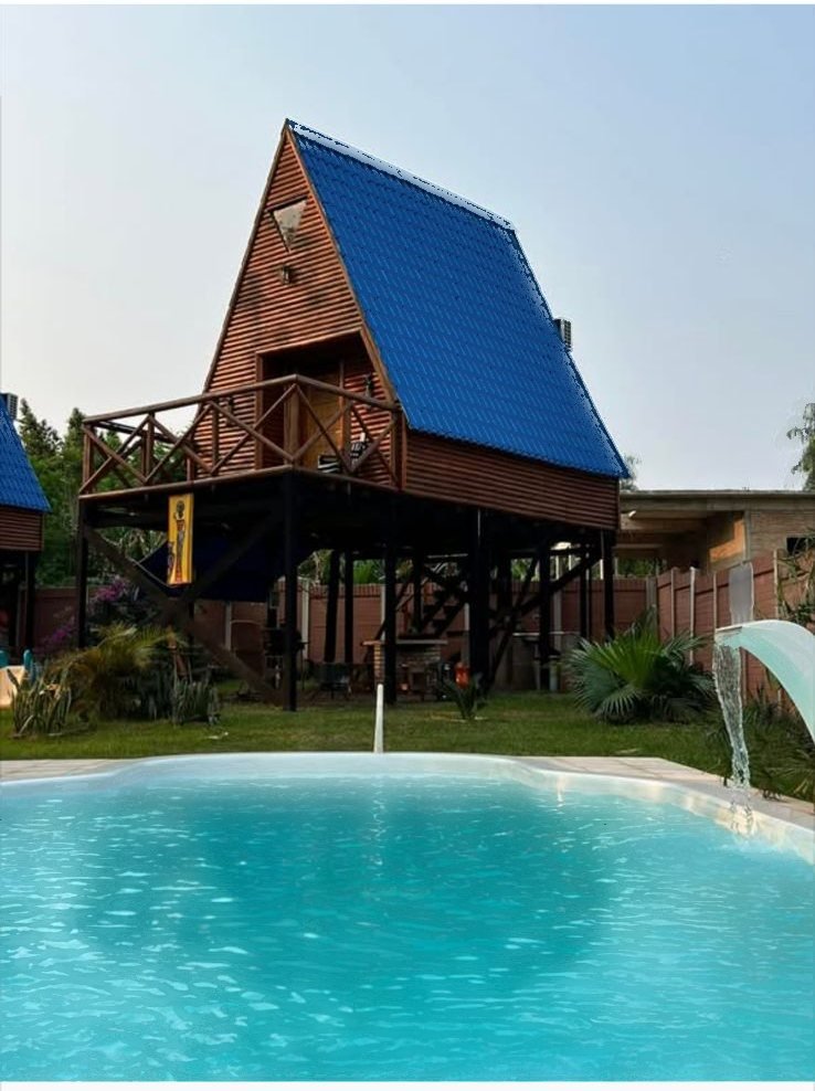 La cabaña de madera sobre la piscina de 40 m², con la cascada en funcionamiento